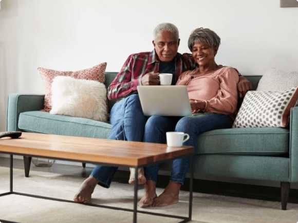 Elderly couple smiling and hugging each other in their kitchen